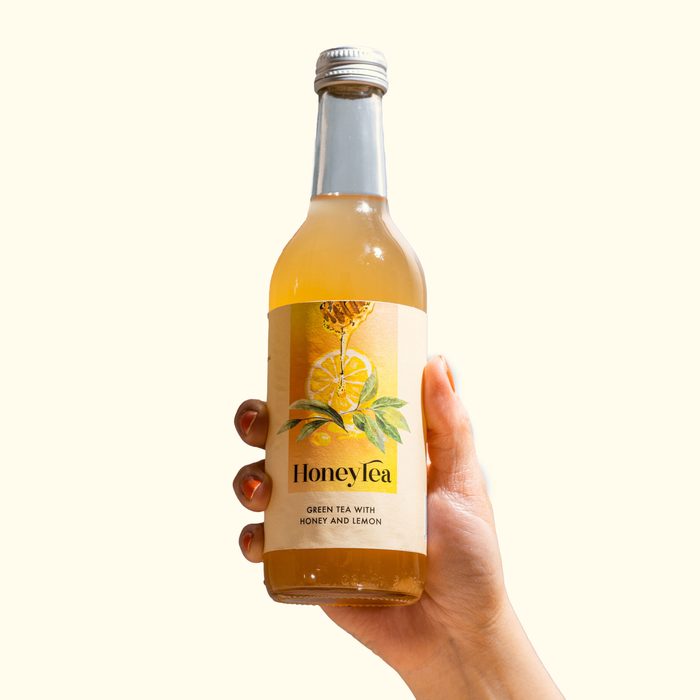 A bottle of HoneyTea held in one hand